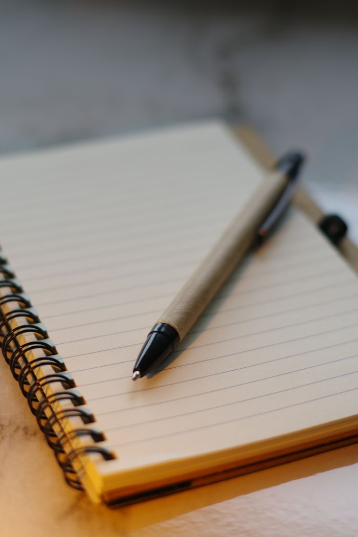 services-01 Close-up of a pen on a spiral notebook, perfect for writing or journaling concepts.