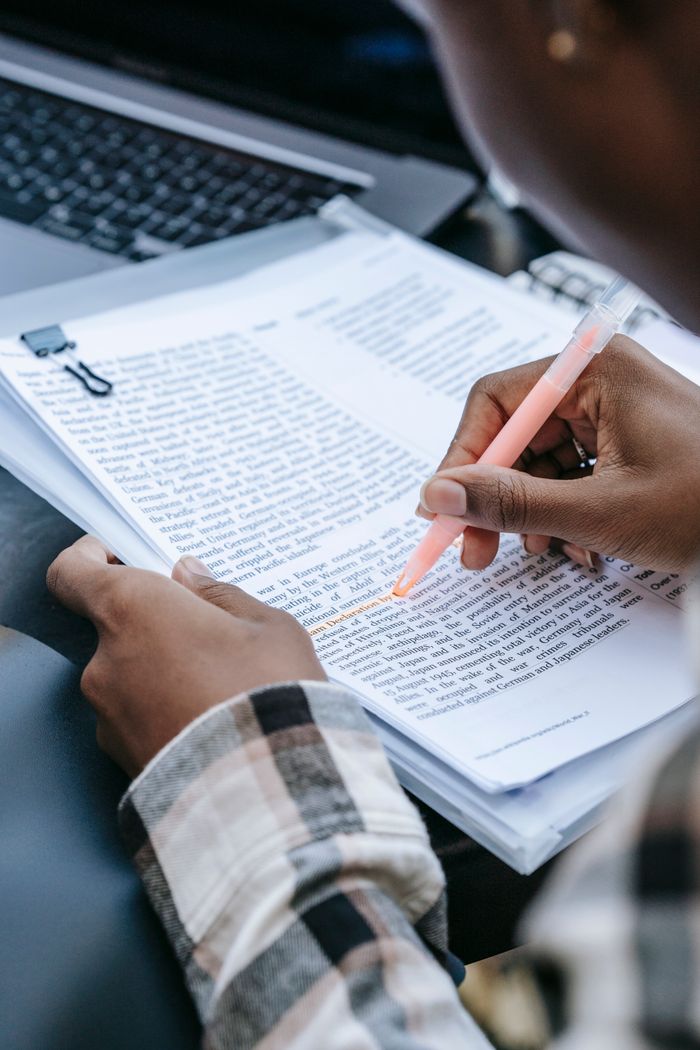 services-img Crop anonymous African American person reading report and highlighting main information with marker while sitting at desk with laptop